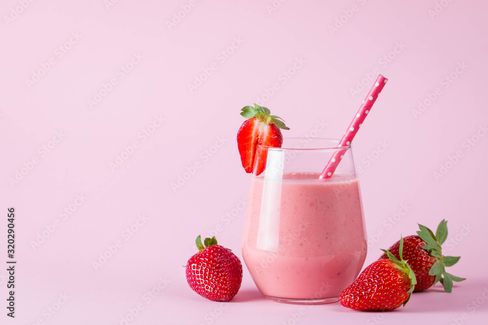 Glass of fresh strawberry milkshake, smoothie and fresh strawberries on pink, white and wooden background. Healthy food and drink concept. Glass of fresh strawberry milkshake, smoothie and fresh strawberries on pink, white and wooden background. Healthy food and drink concept.