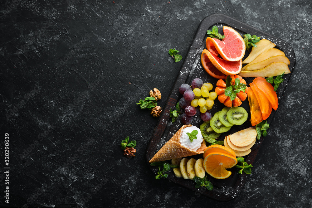 Fruit slicing with ice cream on a wooden board. Top view. Free copy space. Fruit slicing with ice cream on a wooden board. Top view. Free copy space.