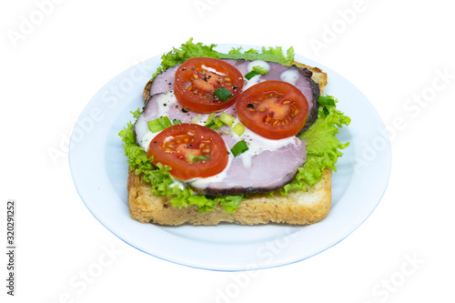 Sandwich with shinka, lettuce, tomato on a plate. Isolated on a white background photo