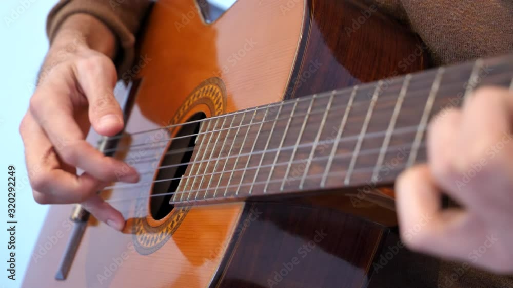 Close up of hands playing guitar. Static, shallow focus Close up of hands playing guitar. Static, shallow focus
