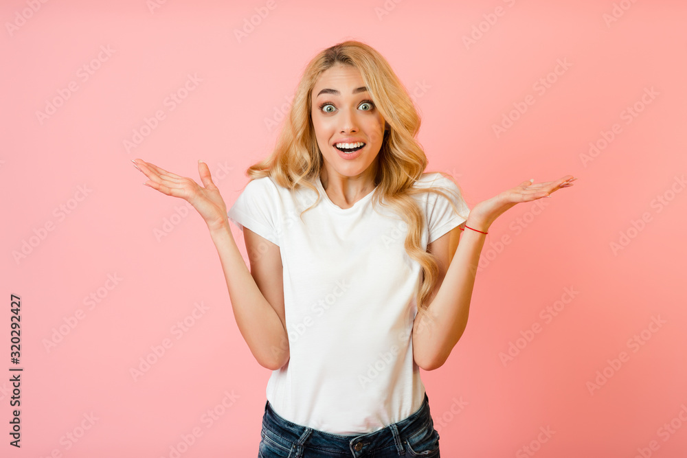 Joy. Surprised woman raising hands and looking at camera Joy. Surprised woman raising hands and looking at camera