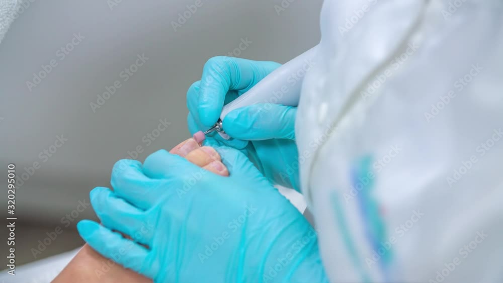 In a spa studio, a beautician is doing an overall treatment of the client's nails. A pedicure. In a spa studio, a beautician is doing an overall treatment of the client's nails. A pedicure.