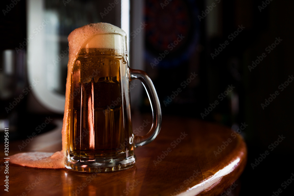 Beer in a Mug with Foam Resting on a Wooden Surface with Blank Space for a Logo or Text