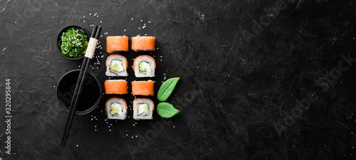 Obraz  z motywem Philadelphia sushi roll with salmon and avocado. Japanese Traditional Cuisine. Top view. Rustic style.