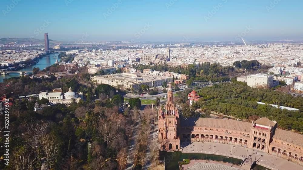 Generic cinematic aerial view of beautiful Espana Square in centre of Sevilla. Close-up of tower. In background beautiful University of Sevilla, Cathedral of Sevilla and river Guadalquivir. Backward Generic cinematic aerial view of beautiful Espana Square in centre of Sevilla. Close-up of tower. In background beautiful University of Sevilla, Cathedral of Sevilla and river Guadalquivir. Backward