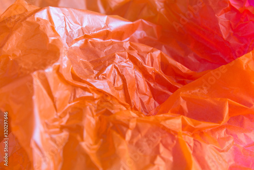 Close up wrinkled orange paper is beautiful. Selective focus with blurred background.