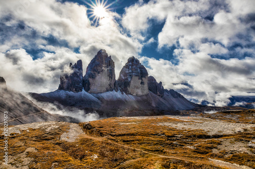 Sunlight on a cloudy day in Dolomites with a view of famous Tre Cime di Lavaredo, Italy