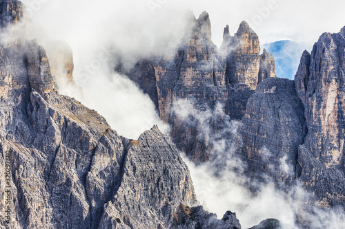Huge rocky mountains view covered with clouds, Dolomites, Italy