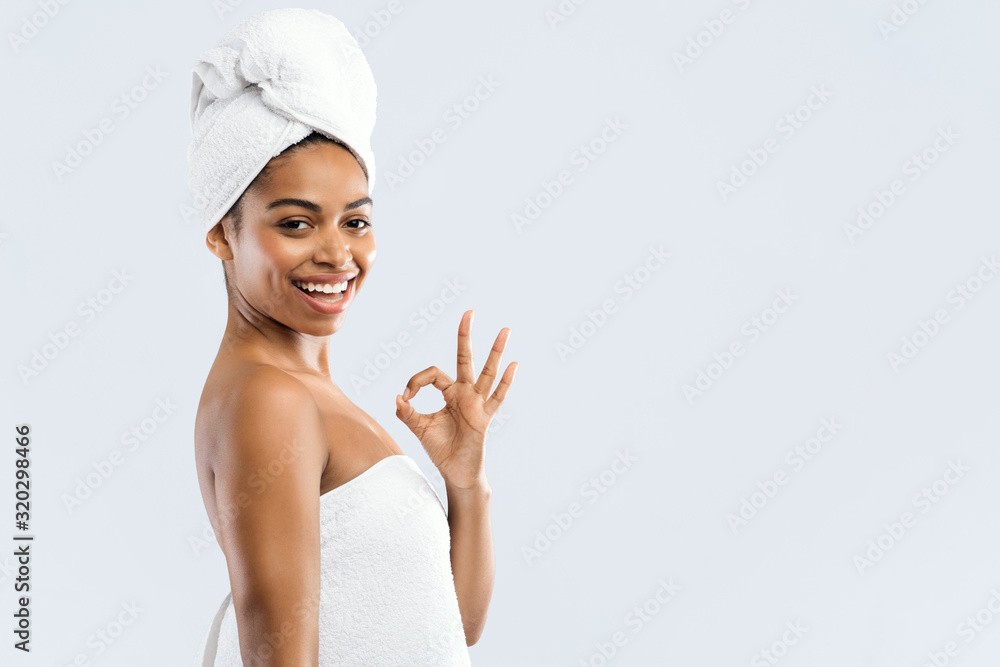 Satisfied black girl in towels showing okay gesture and smiling Satisfied black girl in towels showing okay gesture and smiling