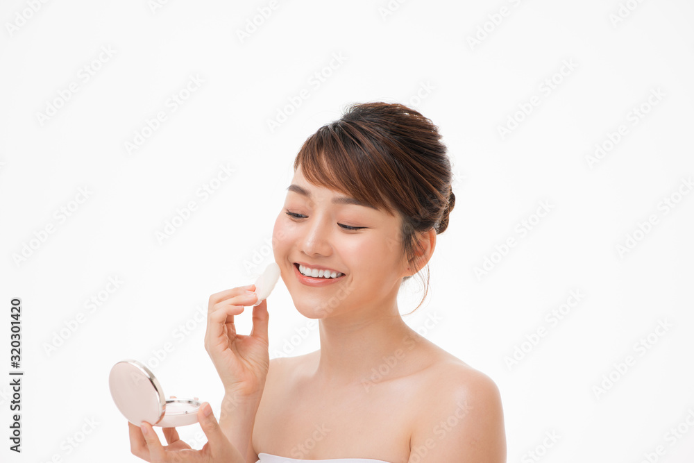Woman applying cosmetic powder puff on her face Woman applying cosmetic powder puff on her face