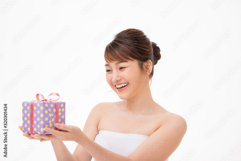 Happy young woman holding small gift box isolated on a white background Happy young woman holding small gift box isolated on a white background