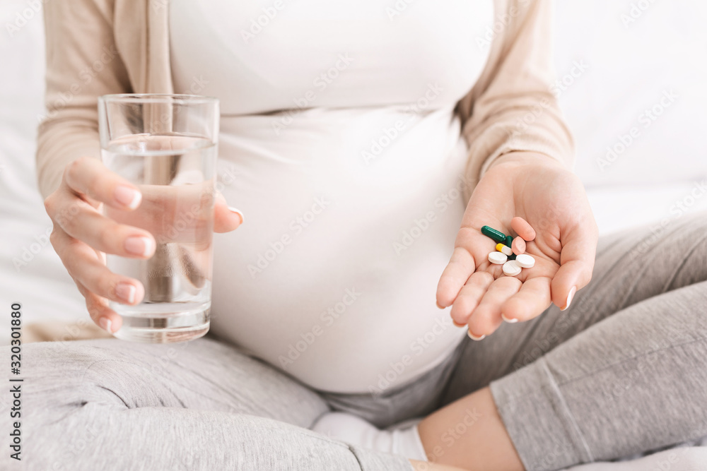 Pregnant woman taking dietary supplements at home Pregnant woman taking dietary supplements at home
