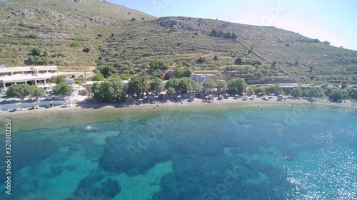 The Clear Blue Water With Coral Reefs In Dyo Liskaria Beach In Island Alina Greece In Background Of Green High Mountains With Variety Of Plants Growing - Aerial Shot photo