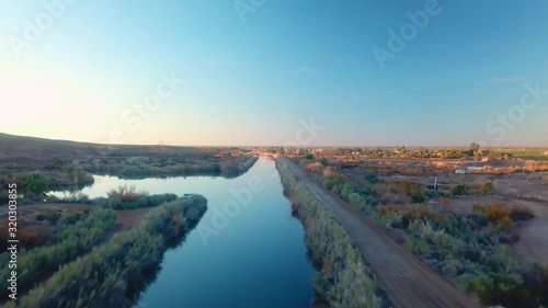 Aerial view along Gila Gravity Irrigation Canal, maintenance road just after sunrise in Yuma, Arizona