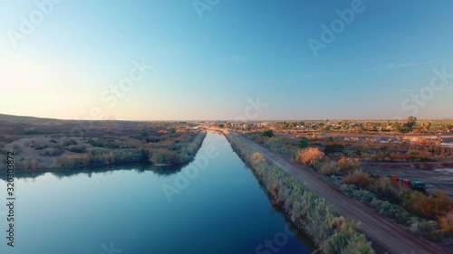 Aerial view of Gila Gravity Irrigation Canal, maintenance road just after sunrise in Yuma, Arizona