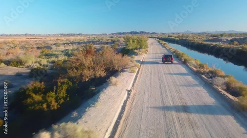 Aerial view of  following an SUV driving on road near Gila Gravity Irrigation Canal - Yuma, Arizona
