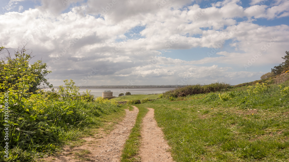 Walking trail at Red Rock, Sutton, County Dublin on the east coast of Ireland. A martello Tower and Dublin Bay can be seen in the distance. Walking trail at Red Rock, Sutton, County Dublin on the east coast of Ireland. A martello Tower and Dublin Bay can be seen in the distance.