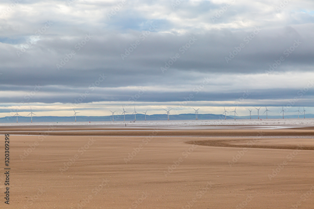 Low tide at Formby beach with an off shore wind farm and the Welsh hills in the distance