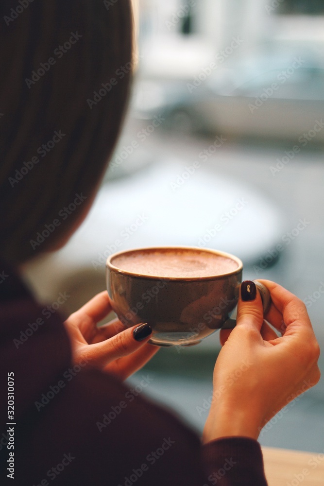 Caucasian young woman enjoying coffee drinking in cafe, close up