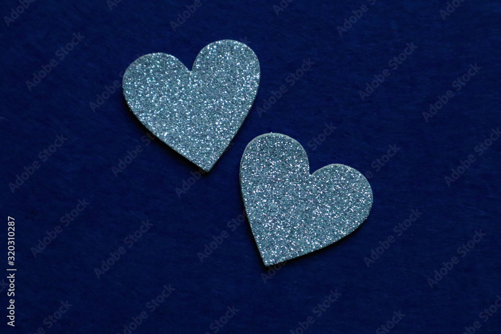 two silver hearts on classic blue background in trendy color of year. Copy space. two silver hearts on classic blue background in trendy color of year. Copy space.