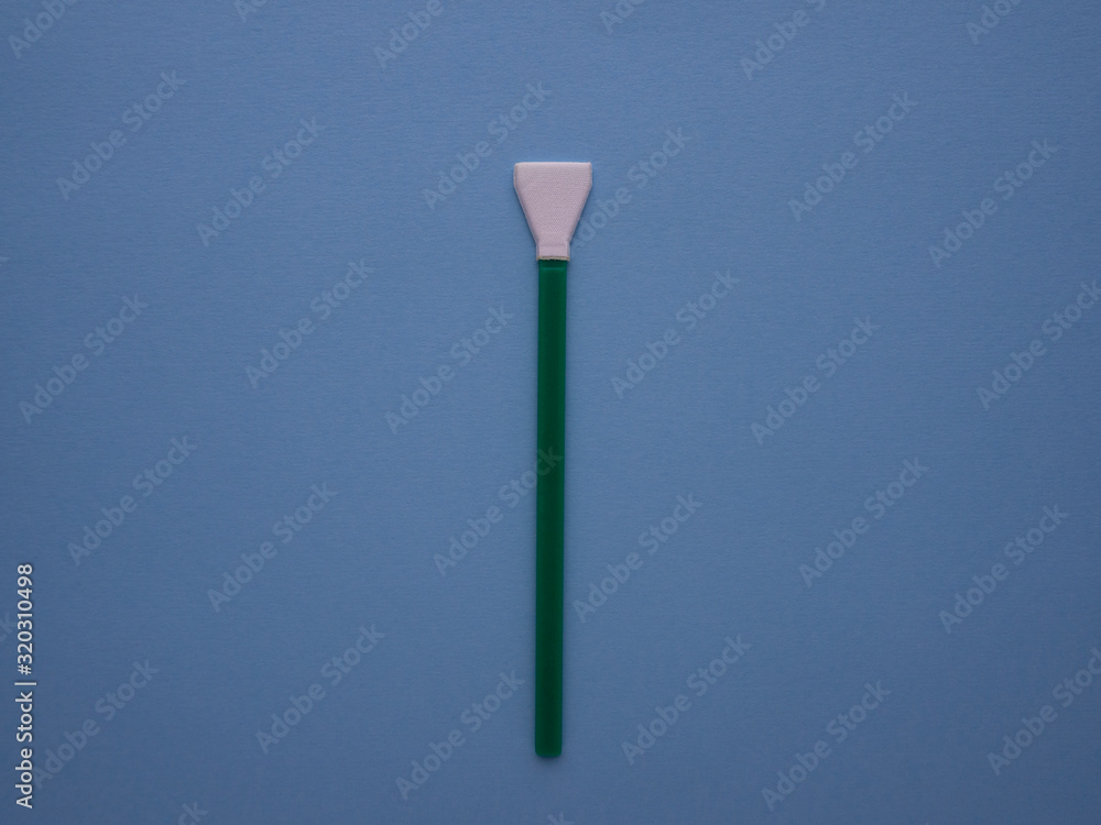 Green cleaning swab for the camera matrix isolated on blue background top view with copy space. Mop for sensor cleaning. Digital camera service. Green cleaning swab for the camera matrix isolated on blue background top view with copy space. Mop for sensor cleaning. Digital camera service.