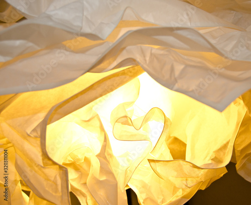 warm and yellow light falls through different layers of paper, light and shadow photo