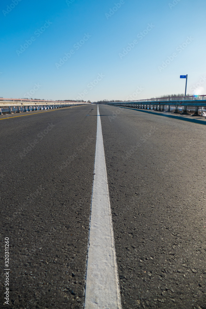 Fototapeta premium marking on the road the white stripe goes into the distance to the point