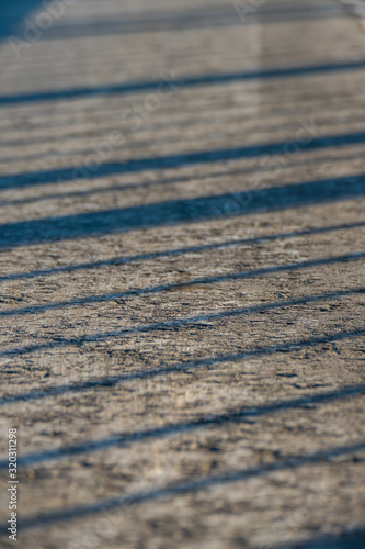 Shadows on the asphalt from the railing