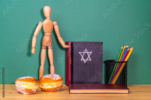 Wooden man next to a religious book and Sufgania photo