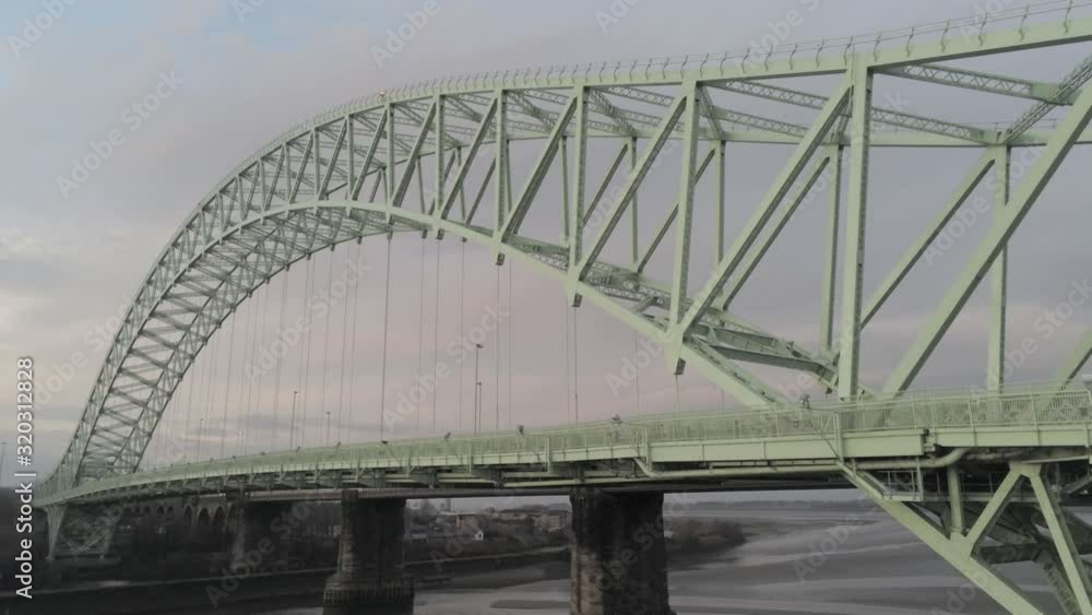 Runcorn Silver Jubilee Bridge aerial view at sunrise. Push in tilt up towards green metal girders. Runcorn Silver Jubilee Bridge aerial view at sunrise. Push in tilt up towards green metal girders.