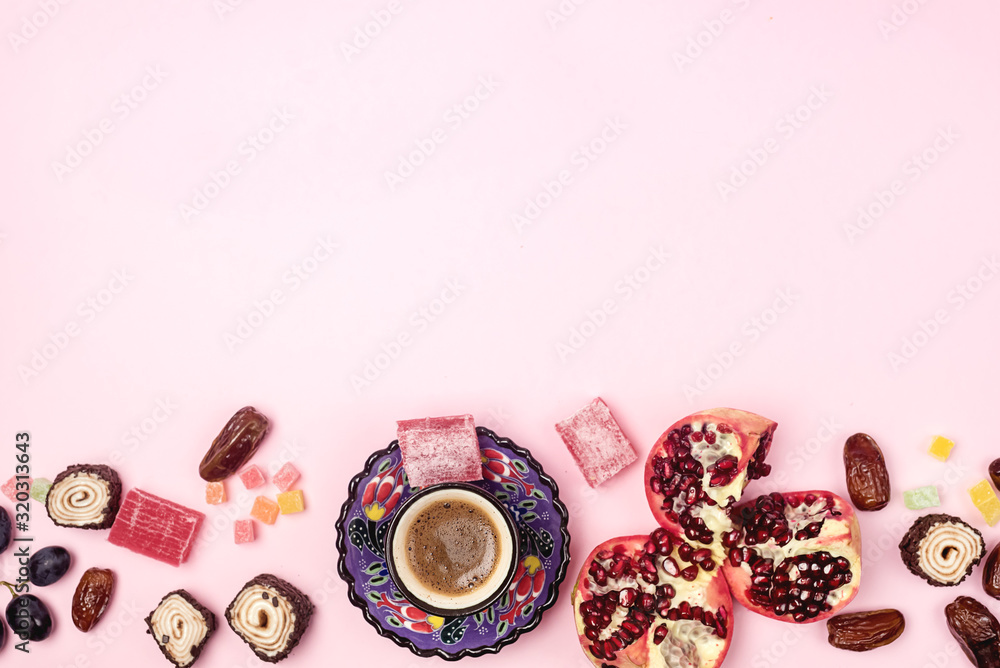 Background FlatLay with Turkish Delight Turkish Coffee Date Fruit and Garnet on Pink Background Top View Copy Space Ramadan