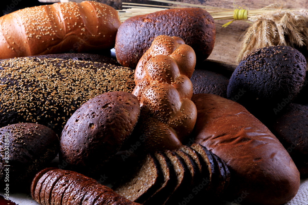 Fresh collection of bread and wheat on the table. Collection of different types of bread: White, rye, seed, form bread. lots of photos of bread with rye ears