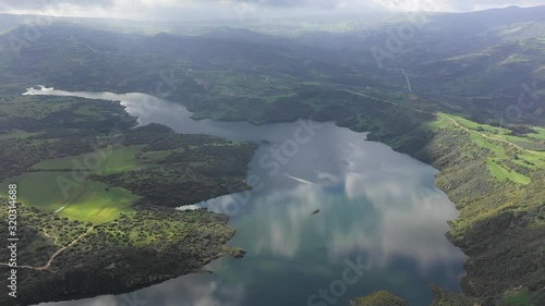 Beautiful scenic aerial view of the Evretou Dam reservoir in Cyprus with clouds reflecting in the water and lush green hills surrounding the lake. photo