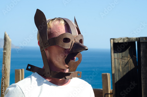 medieval torture mask on blond man