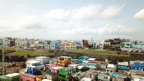 Pull Back Aerial View of La Perla, Shanty and Colorful District of San Juan Puerto Rico on Atlantic Ocean Coastline photo