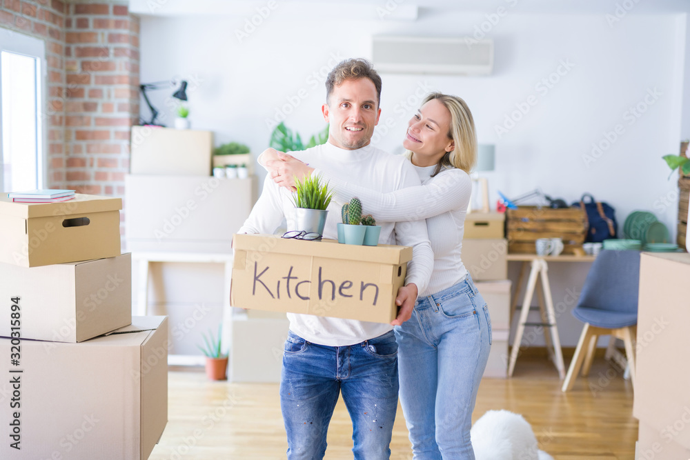Young beautiful couple with dog moving cardboard boxes at new home Young beautiful couple with dog moving cardboard boxes at new home