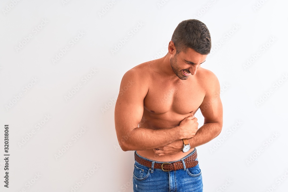 Young handsome shirtless man showing muscular body over isolated background with hand on stomach because nausea, painful disease feeling unwell. Ache concept.