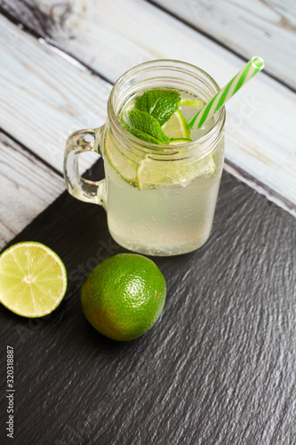 .Lemonade with lemons on a slate board and wooden background..Summer drink. Lemon fresh.