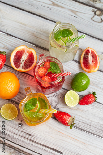 Summer drinks. Fresh freshes on a wooden background. View from above. Orange  lemon and strawberry fresh.