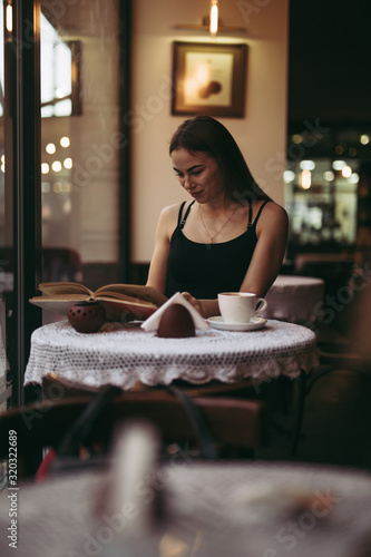 Young woman reading book in cafe