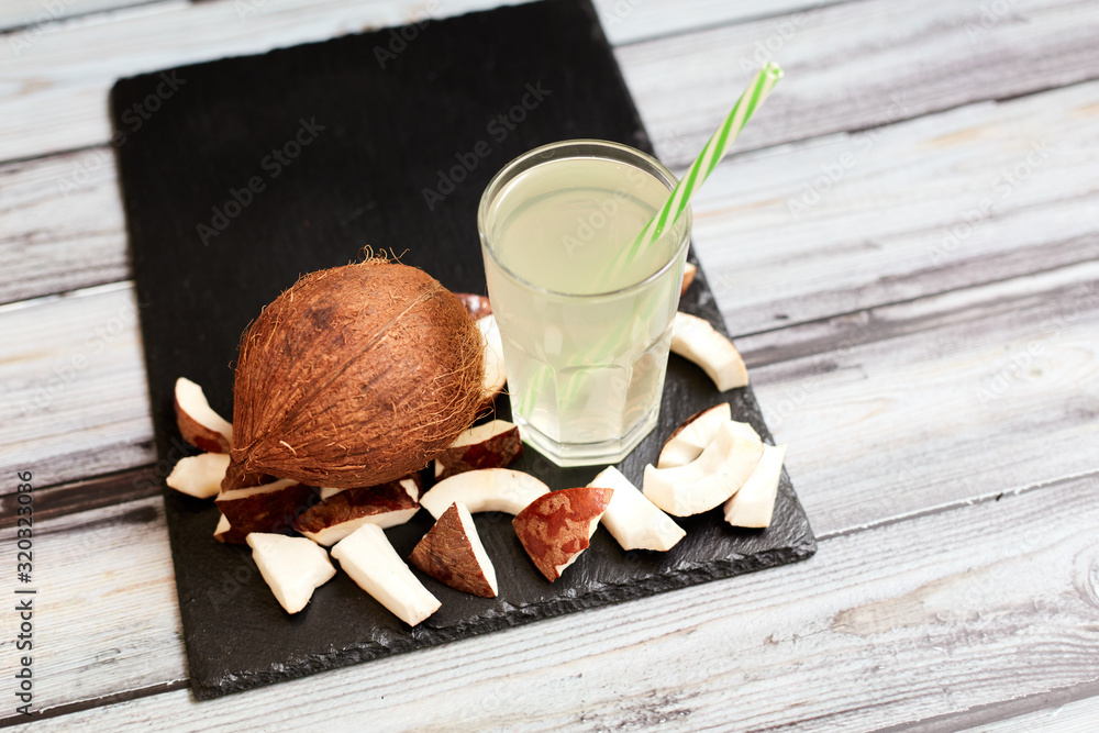 Coconut and coconut juice on a wooden background. View from above.