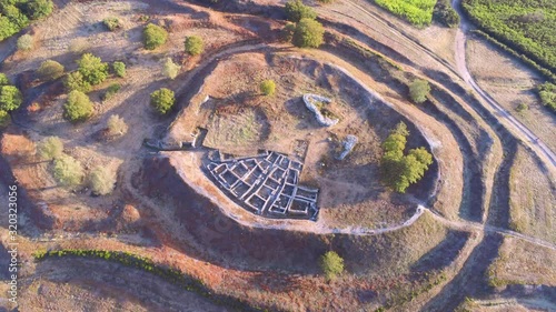 Ruins of Castromaior in sunny day. Aerial, zoom out photo