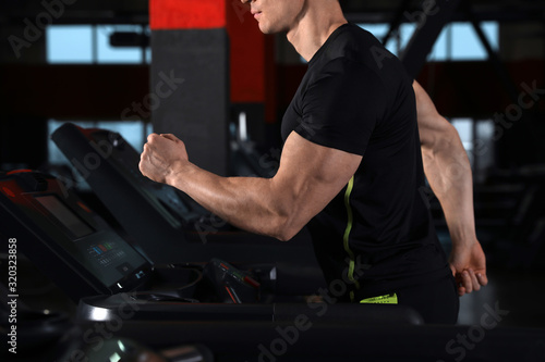 Man working out on treadmill in modern gym, closeup © New Africa