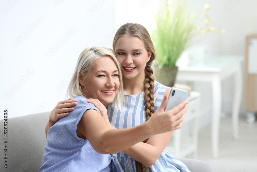 Happy mother and daughter taking selfie at home Happy mother and daughter taking selfie at home