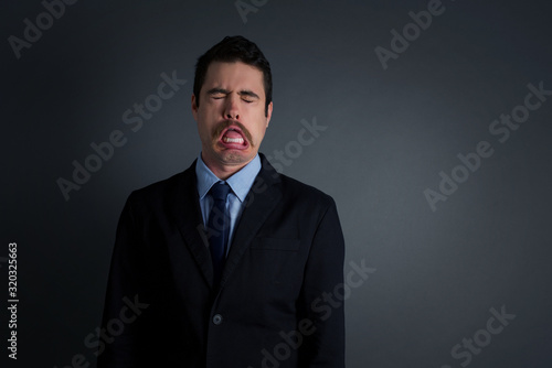 Negative human expressions and attitude. Angry dissatisfied male has disgusting expression as sees something not appealing, frowns face, isolated over white  background. Distaste and dislike © Jihan