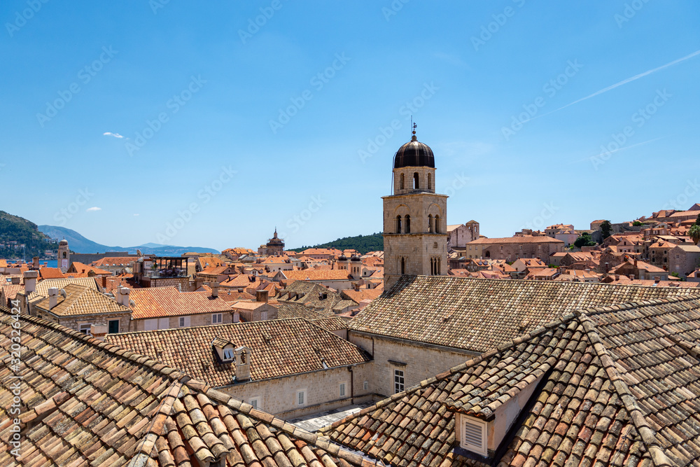 A photograph showing the UNESCO World Heritage Site Dubrovnik, Croatia. A number of terracotta roof tops and historical buildings are positioned within the walled city of Dubrovnik. 