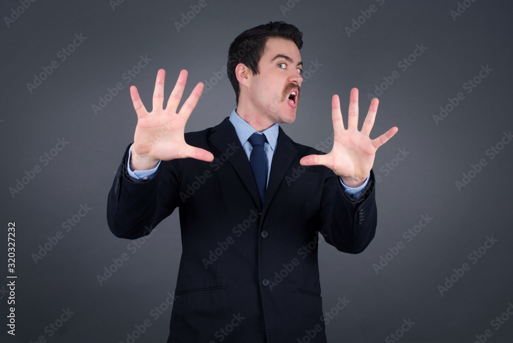 Dissatisfied male model frowns face, has disgusting expression, shows tongue, expresses non compliance, irritated with somebody, rejects do something. People and negative facial expressions Dissatisfied male model frowns face, has disgusting expression, shows tongue, expresses non compliance, irritated with somebody, rejects do something. People and negative facial expressions
