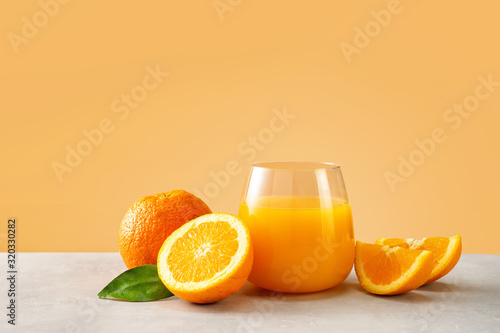 Tableau sur toile Close up of orange juice in a glass with oranges against trendy yellow backgroun