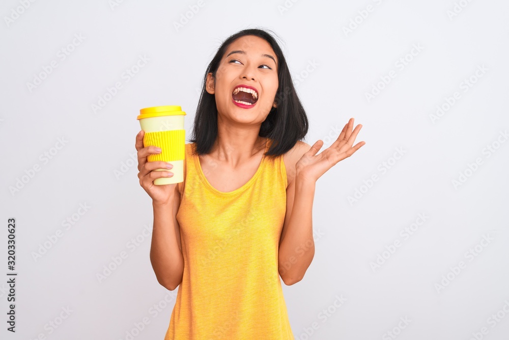 Young chinese woman drinking take away glass of coffee over isolated white background very happy and excited, winner expression celebrating victory screaming with big smile and raised hands Young chinese woman drinking take away glass of coffee over isolated white background very happy and excited, winner expression celebrating victory screaming with big smile and raised hands