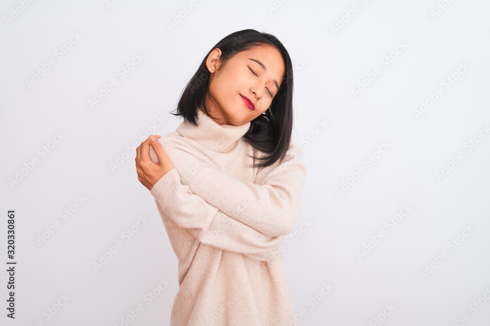 Young chinese woman wearing turtleneck sweater standing over isolated white background Hugging oneself happy and positive, smiling confident. Self love and self care Young chinese woman wearing turtleneck sweater standing over isolated white background Hugging oneself happy and positive, smiling confident. Self love and self care